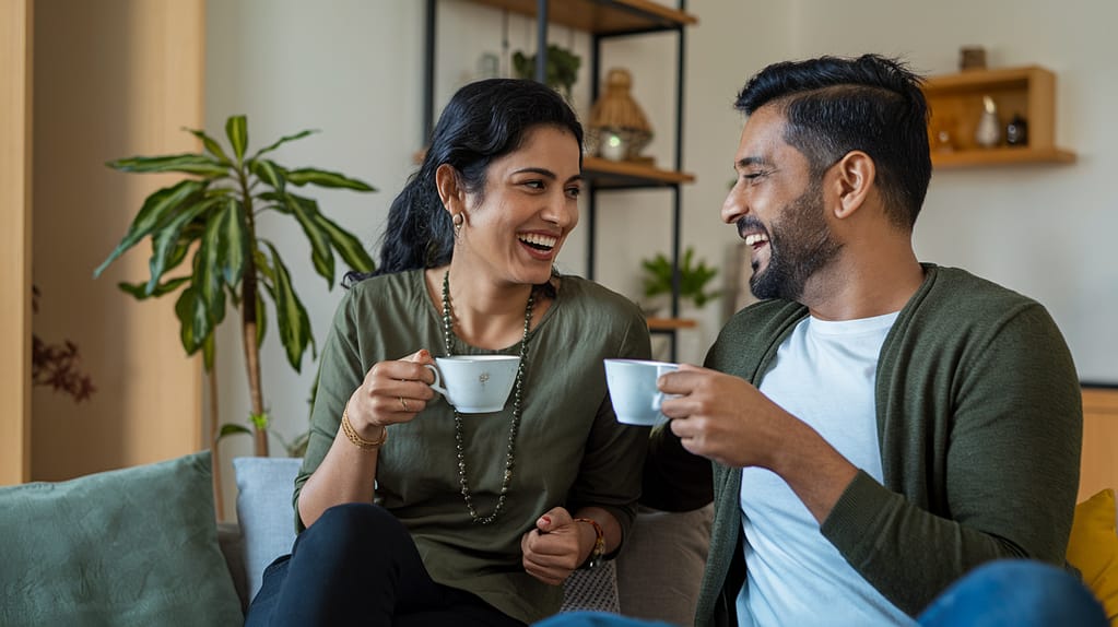 A couple enjoying a cup of tea from the comfort of their couch